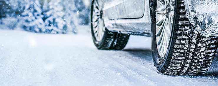 Winter tire. Car tire on snow road. Tires on snowy road detail.